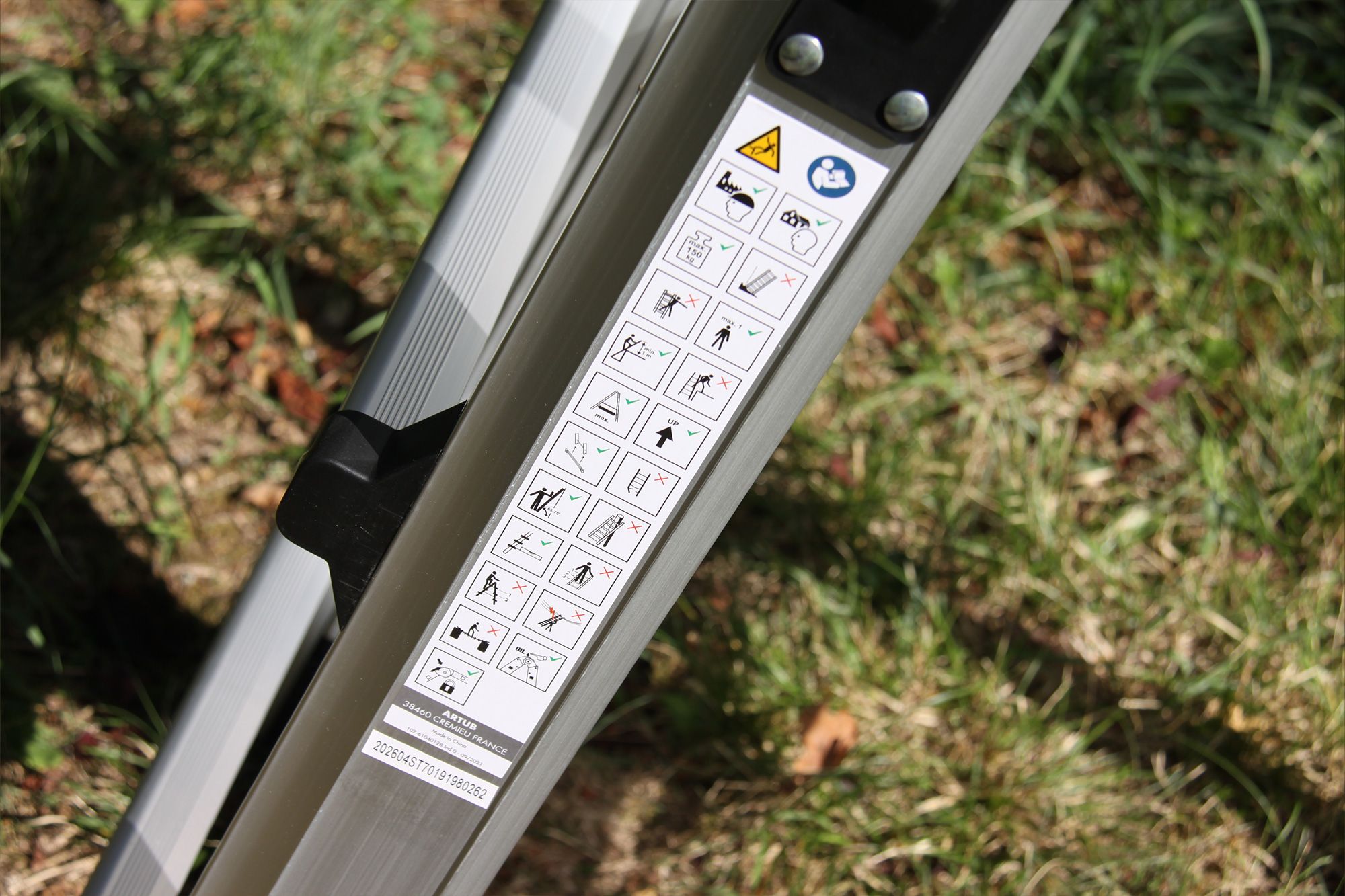 Close-up of a silver equipment leg with a label displaying multiple safety pictograms.
