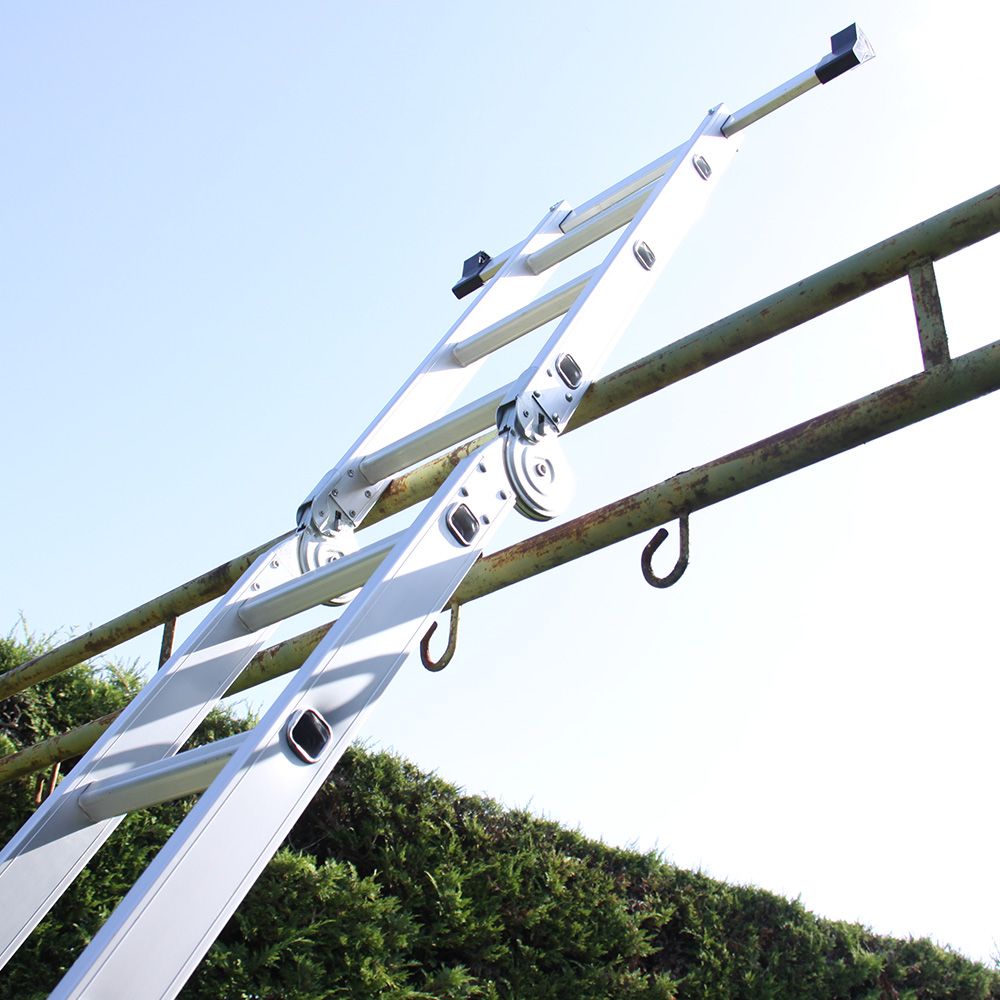 A shiny metal ladder is securely attached to a wooden fence against a bright sky.